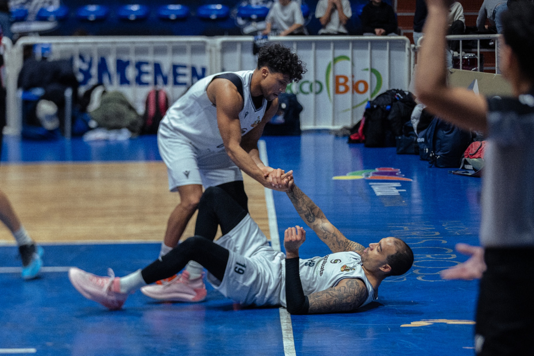 Giocatore di basket in tiro sotto luce di scena